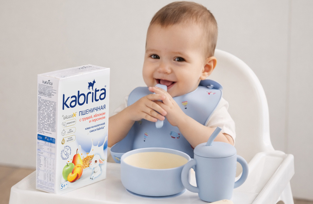 Малыш в стульчике для кормления рядом с пшеничной кашей Kabrita для прикорма