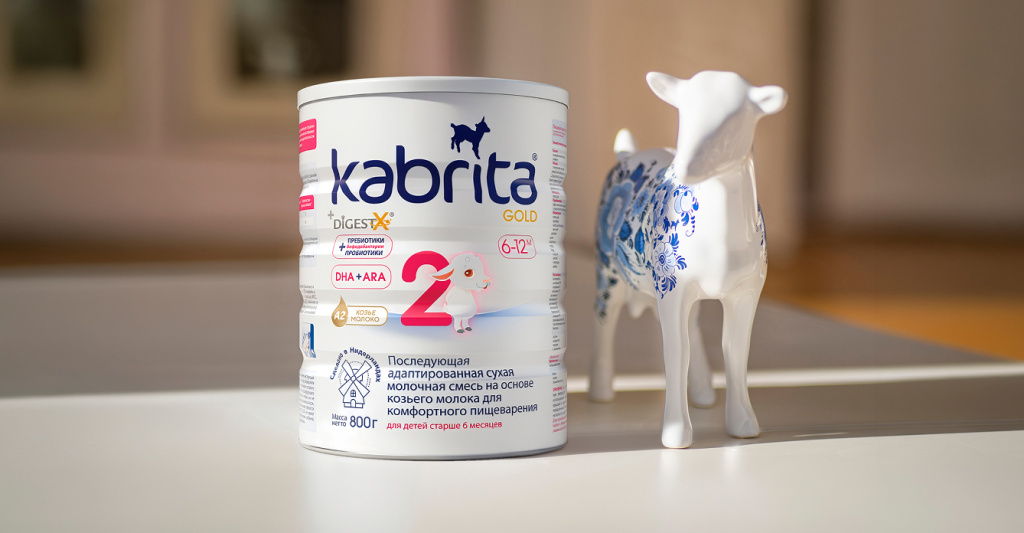 Банка смеси Kabrita Gold рядом с декоративной фигуркой козы