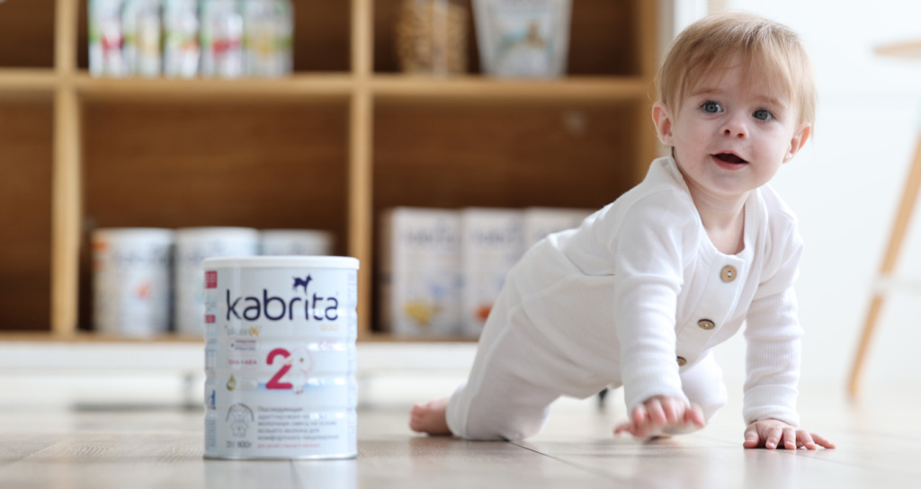 Малыш ползает рядом с банкой смеси Kabrita 2 — комфортное пищеварение и гармоничное развитие