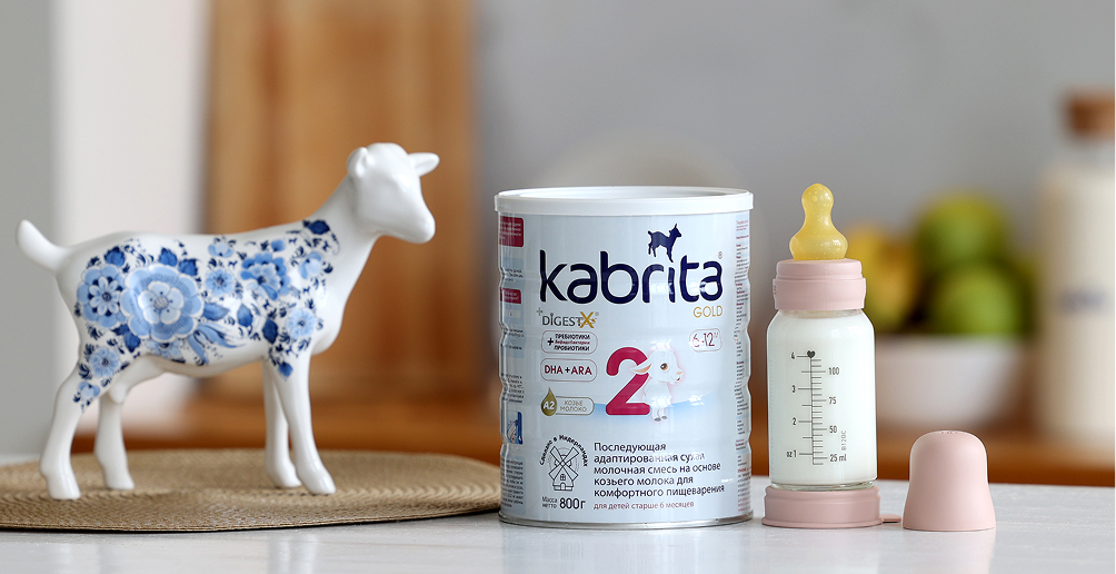 Банка детской смеси Kabrita рядом с бутылочкой и фигуркой козы