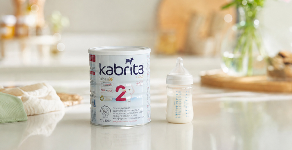 Банка смеси Kabrita и бутылочка с молочной смесью на кухне